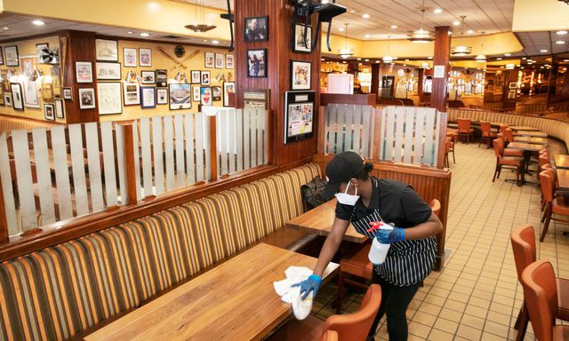 An employee wiping down a table inside of Junior's